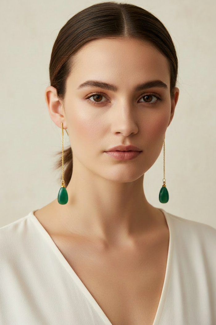 Model wearing shorter green gemstone drop earrings