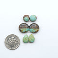 Number 8 Turquoise cabochons, blue and green color with brown matrix, polished stones on a white background, with a US dime for scale