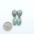 Number 8 Turquoise cabochons, blue and green color with brown matrix, polished stones on a white background, with a US dime for scale