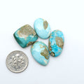 Royston Turquoise cabochons, blue-green color with natural matrix, polished stones on a white background, with a US dime for scale