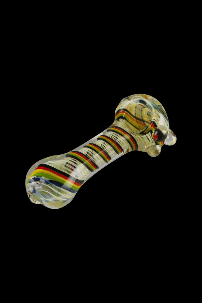 A close-up of the Worked Rasta Spoon Glass Pipe, showing a curved glass pipe with red, yellow, and green details against a black background.